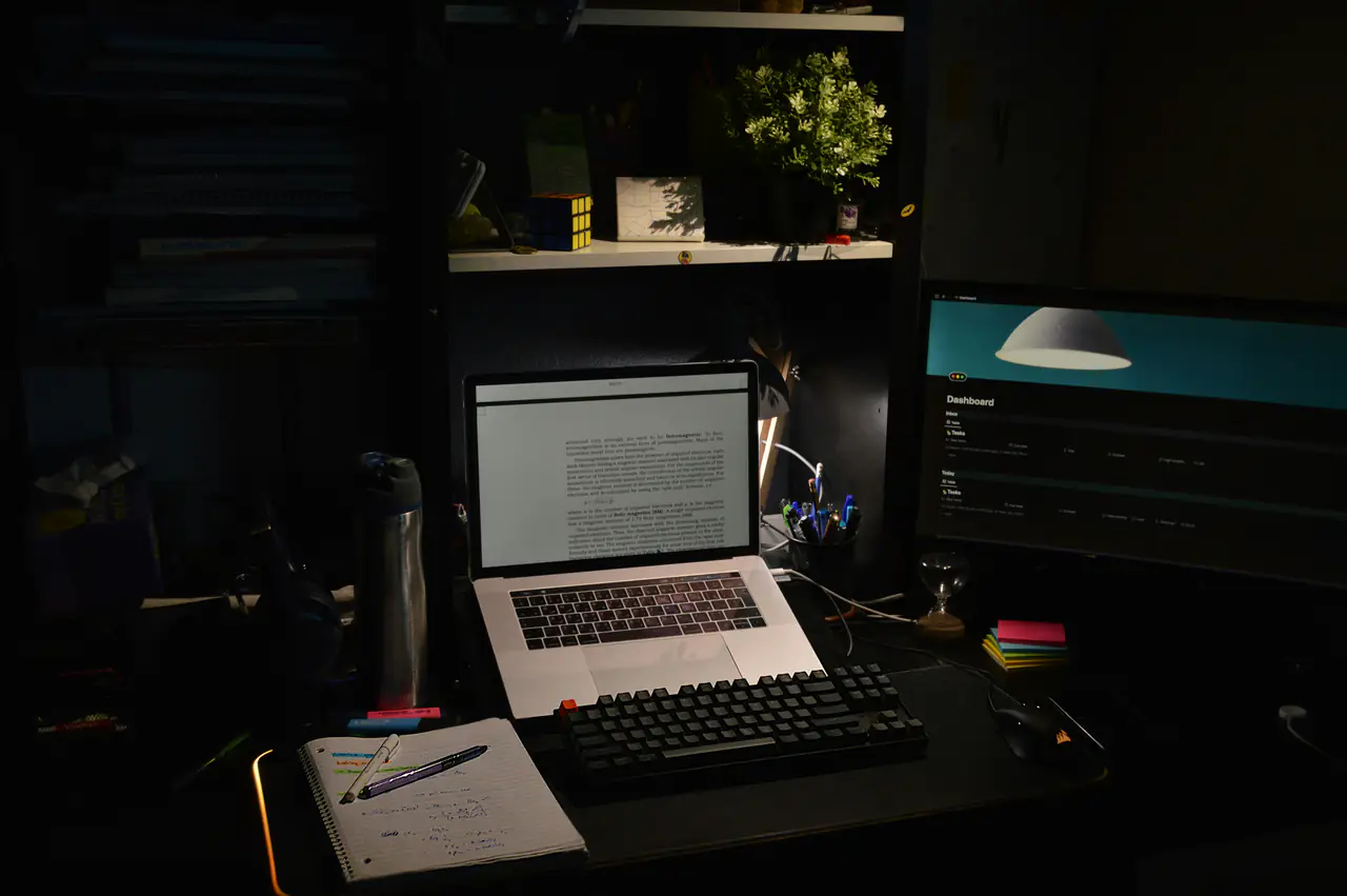 Bureau sombre avec un ordinateur portable allumé