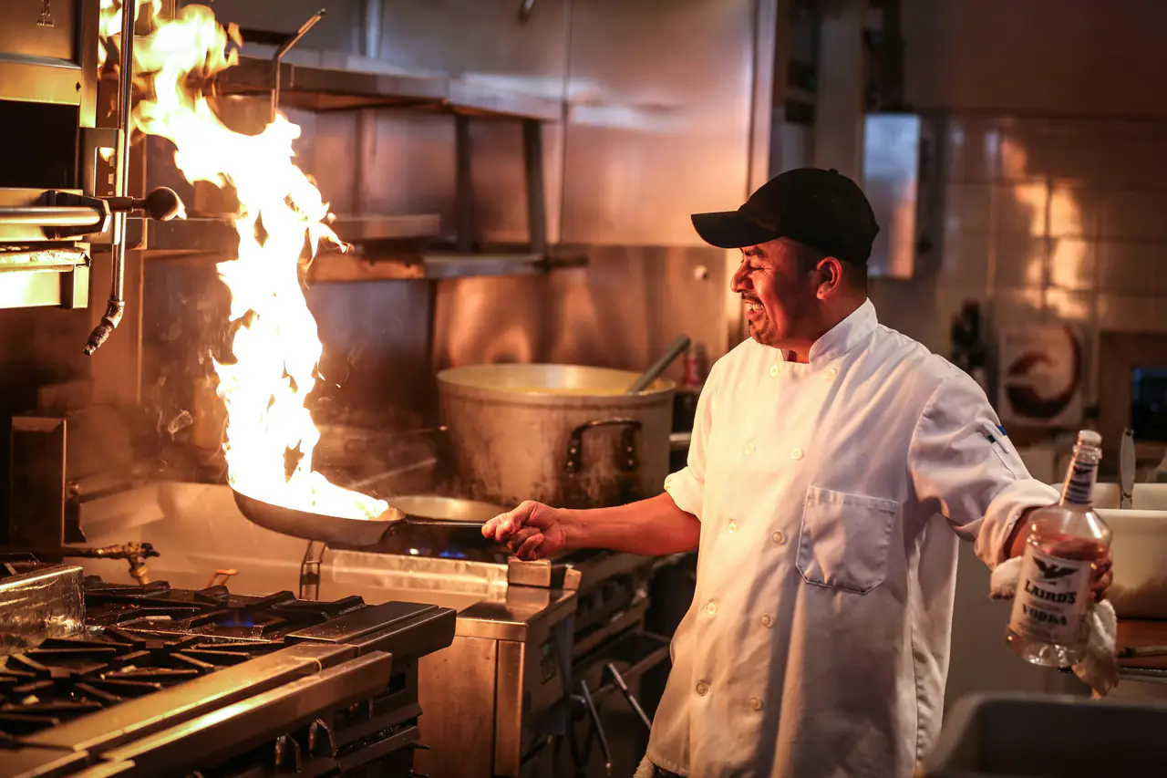 Chef faisant flamber une poêle en cuisine