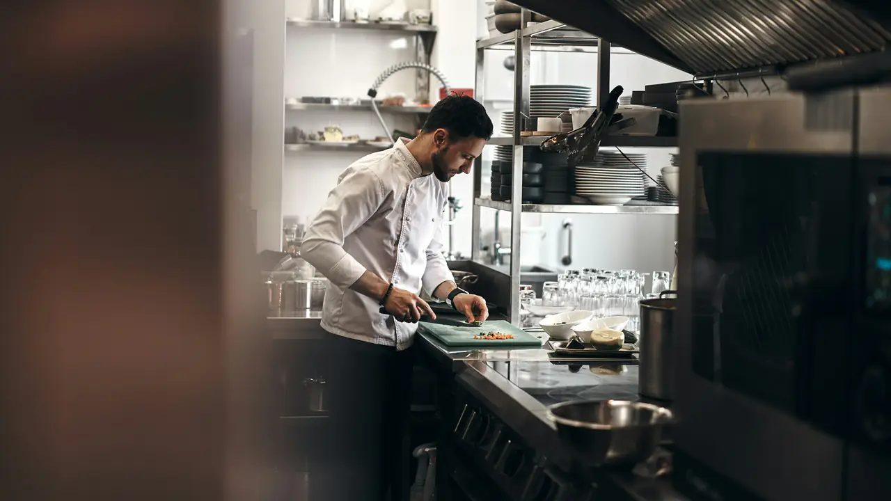 Cuisinier en train de préparer des légumes dans une cuisine de restaurant