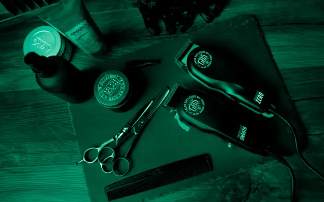 Tondeuses, ciseaux et peigne posés sur un plan de travail de barbier