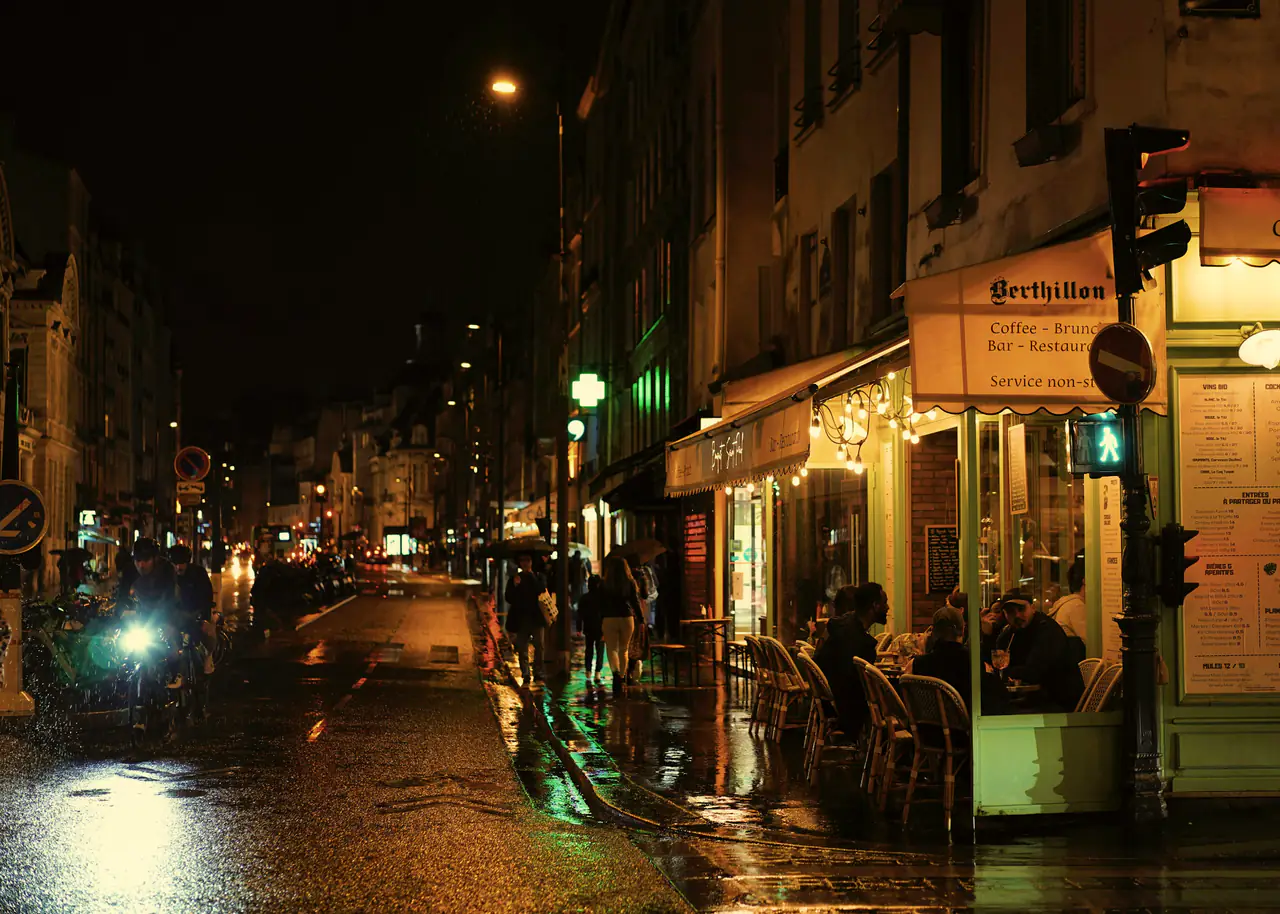Rue parisienne de nuit avec des terrasses éclairées