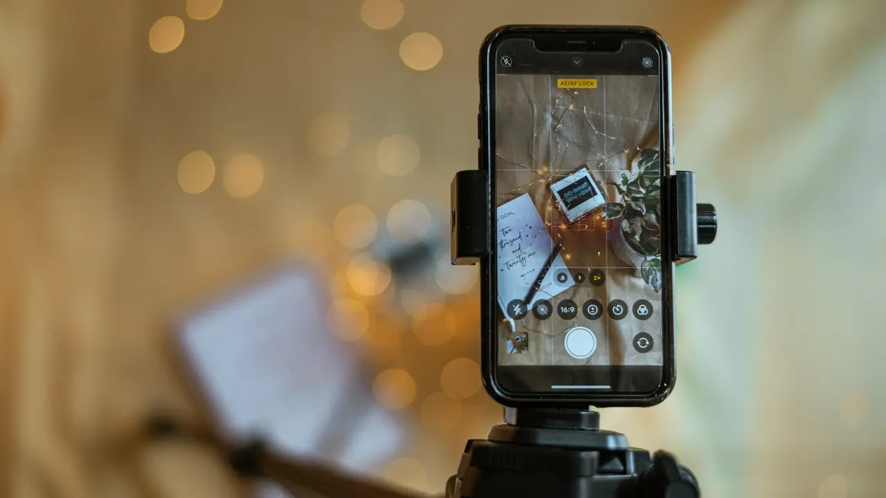 Téléphone sur trépied qui filme des produits posés sur une table
