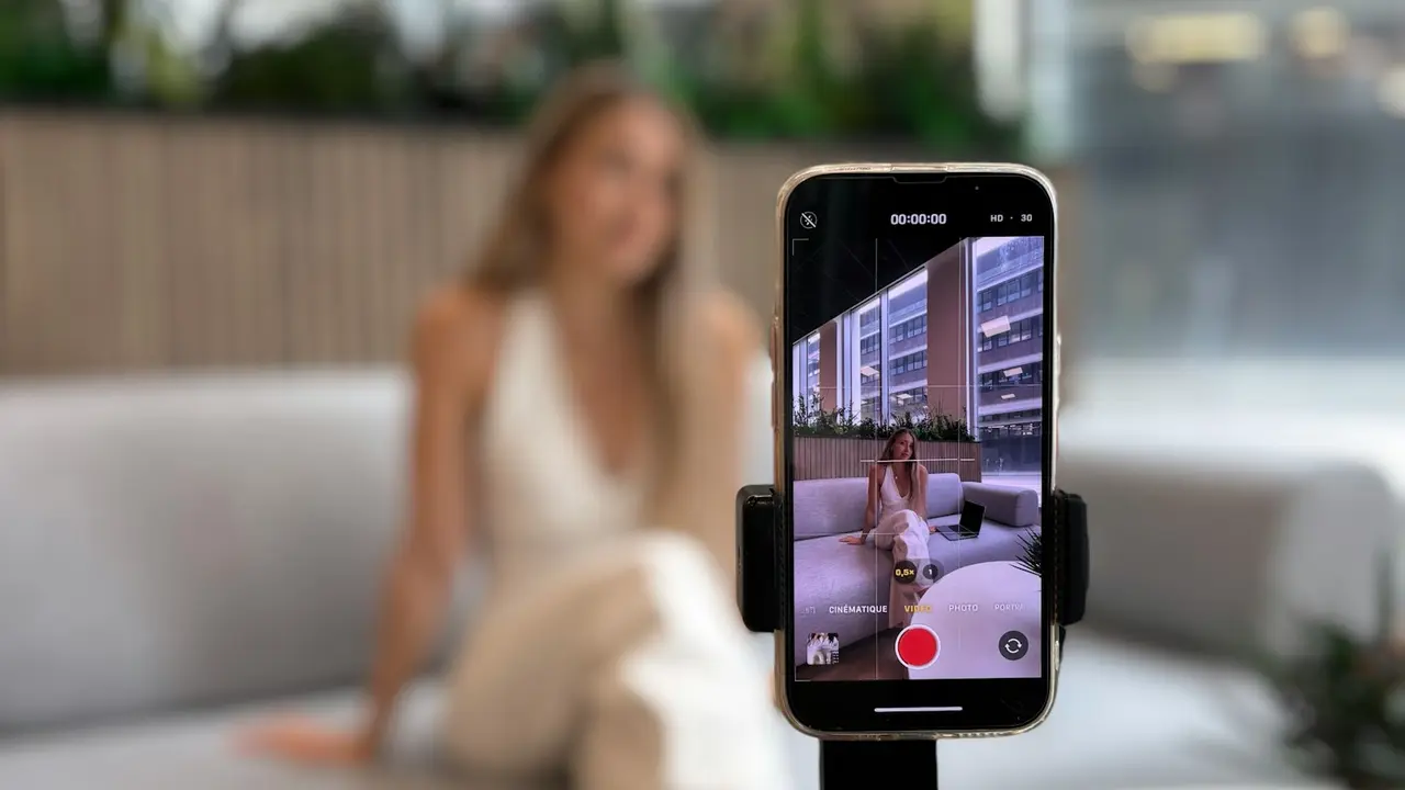 Créatrice filmée au téléphone sur un trépied, dans un salon